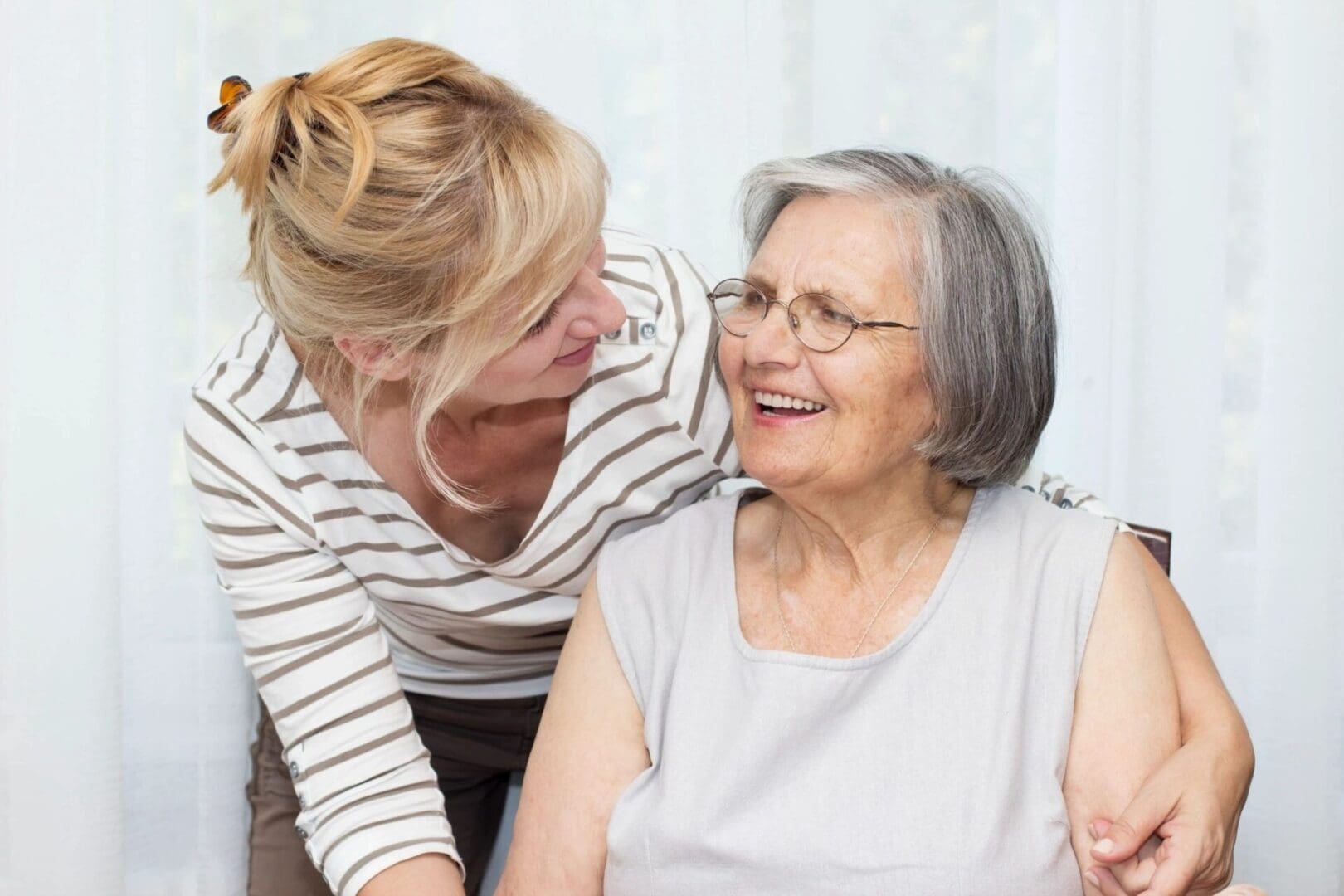 A woman and an older person smiling for the camera.