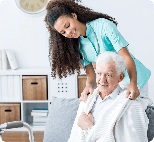 A woman helping an old man to get dressed