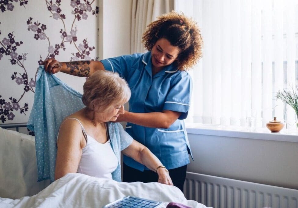 A woman is helping another person in bed