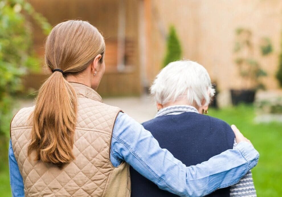 A woman and an older man are holding each other.